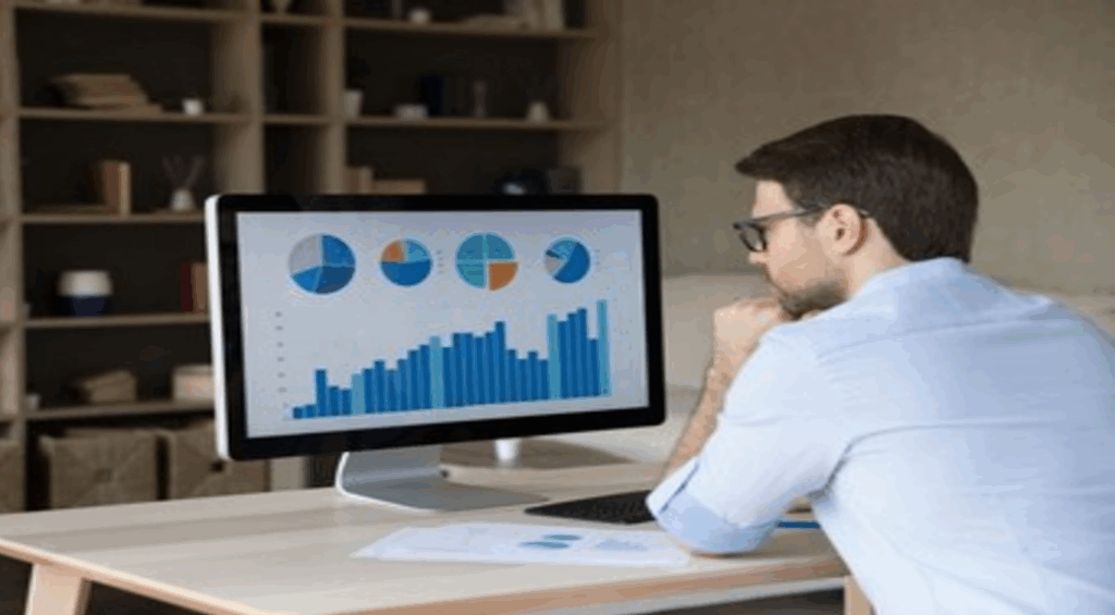 Gráficos financeiros e moedas com um smartphone exibindo "Orçamento Pessoal", representando a tecnologia simplificando o controle financeiro.