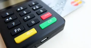 Família brasileira analisando documentos financeiros e um cartão de crédito, buscando como sair das dívidas do cartão de crédito