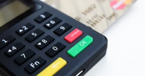 Smartphone exibindo gráficos financeiros e setas entre logos de bancos, representando a portabilidade de crédito digital e a facilidade de transferir dívidas para melhores condições.